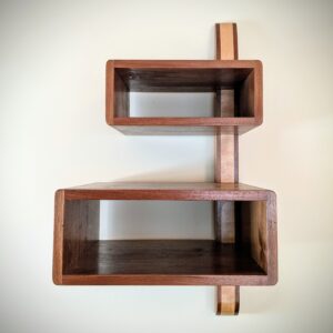 The DiStefano Shelf.  A walnut and ash spline connects two walnut boxes.  Rock solid and weightless at once.